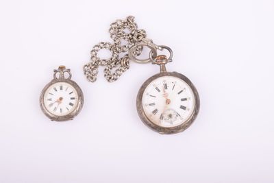 deux horloges posées l'une à côté de l'autre sur une surface blanche