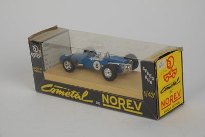 une petite voiture bleue dans une boîte posée sur une surface blanche