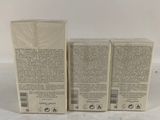 three boxes of cream sitting on top of a white table