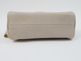 a close up of a white purse on a white surface