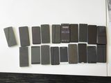 several cell phones are arranged on a white surface next to a magazine