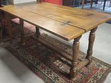 une table en bois avec un plateau en bois, posée sur un tapis dans une pièce