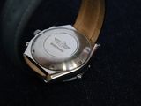 a close up of a watch on a black surface