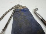 a purse with a chain and a hammer on a table