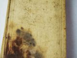 an old book sitting on top of a white table covered in dirt