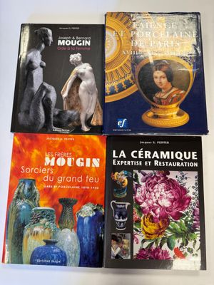 quatre livres posés sur une table sur laquelle se trouvent des vases et des tableaux