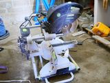 someone is using a circular saw to cut a piece of wood in a garage