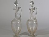 two clear glass vases sitting on top of a white table