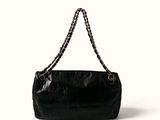 the large black bag is sitting on the white surface