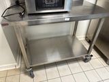 un micro-ondes posé sur une table en inox dans une cuisine