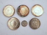 six different types of coins are shown on a white surface