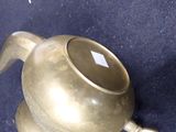 a gold tea pot sitting on a blue surface