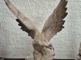 a statue of an eagle on a table next to a lamp