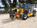 un petit tracteur garé sur un terrain en terre battue