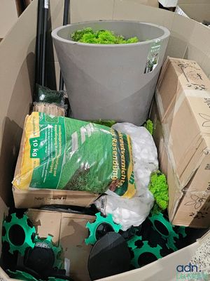 une caisse remplie de matériel de jardinage et un seau rempli de plantes