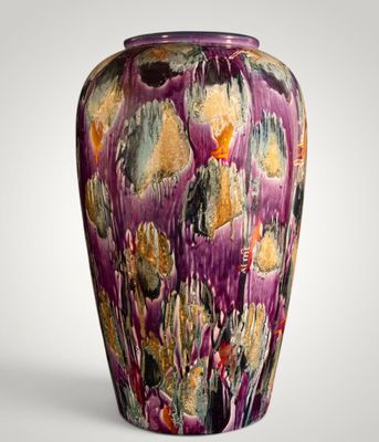 un vase violet posé sur une surface blanche