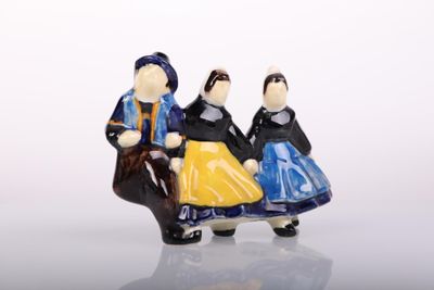 three figurines of people sitting on a bench