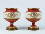 une paire de vases rouges et blancs ornés de motifs dorés