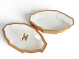 pair of gold and white porcelain dishes with a bird in the center