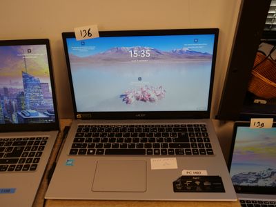 three laptops are sitting on a table with price tags on them