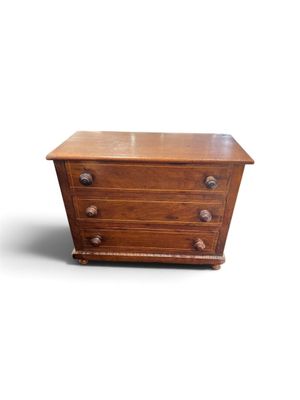 une petite commode en bois sur fond blanc