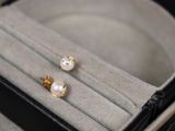 une paire de boucles d'oreilles en perles dans un écrin posé sur une table