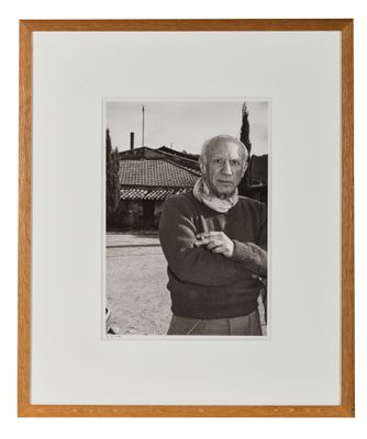 photographie en noir et blanc d'un vieil homme debout devant une maison