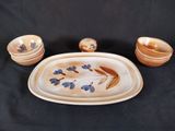 several pieces of pottery are sitting on a black surface
