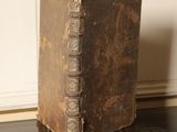an old book sitting on top of a black table