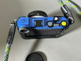 a blue camera with a blue strap and a black camera