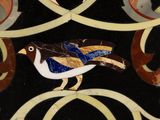 a bird that is sitting on a decorative tile