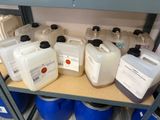 many containers of liquid sitting on a shelf in a room