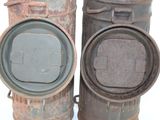 two old metal containers sitting next to each other on a white surface