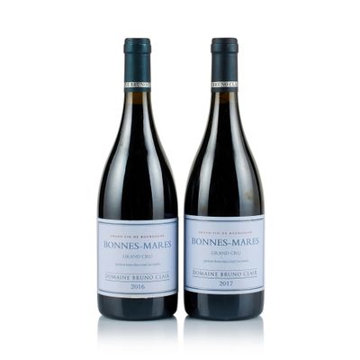 two bottles of wine sitting next to each other on a white surface