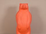 une statue orange représentant un ours debout sur ses pattes arrière