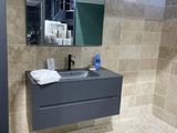 une salle de bains avec un lavabo et un miroir au mur