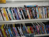 a shelf full of dvd ' s on a shelf in a room