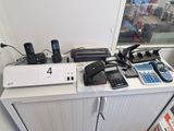 beaucoup de téléphones portables posés sur un bureau, avec plein de fils
