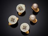 quatre anneaux ornés de perles et d'or sur un fond noir