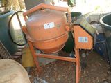 une bétonnière orange posée au milieu d'un tas d'ordures