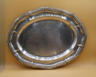 a silver plate that is sitting on a shelf