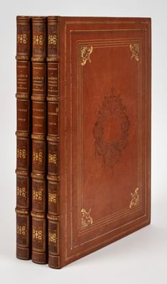 un ensemble de trois livres reliés en cuir, empilés les uns sur les autres