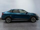 a blue car is parked in a room with a white wall