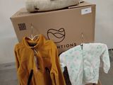 une pile de vêtements posée sur une palette à côté d'un carton