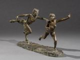 two bronze statues of a man and a woman playing with a frisbee