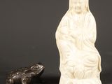 une statue représentant une femme et une grenouille assises l'une à côté de l'autre
