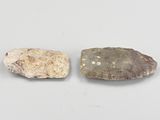 deux petits cailloux posés l'un à côté de l'autre sur une surface blanche