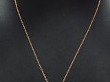 a black and gold necklace with a square pendant on a mannequin neck