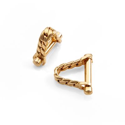 un gros plan sur deux boucles d'oreilles en or sur fond blanc