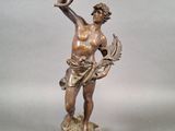 une statue antique en bronze représentant un homme tenant une lampe, posée sur un socle en bois